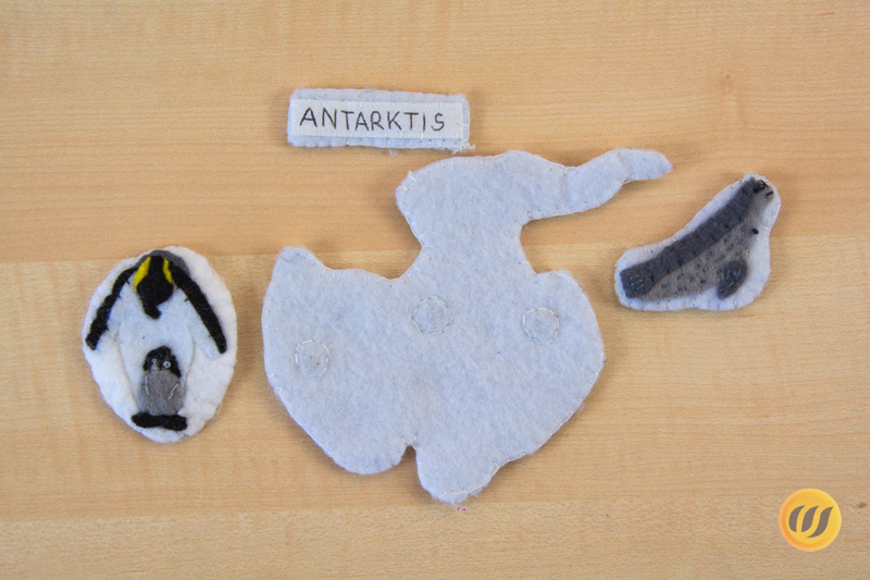 Kaiserpinguin und Seeleopard mit dem Kontinent Antarktika